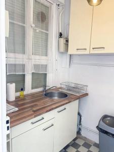 una piccola cucina con lavandino e finestra di Fabre / Appartement central proche de la gare a Antibes