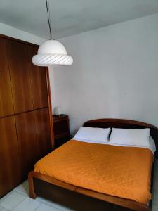 a bedroom with a bed with an orange blanket at Villa Raffaella in Lecce
