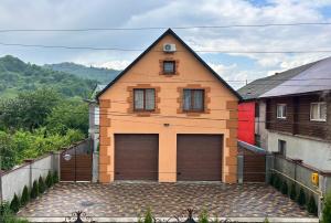 a large house with two garage doors on it at Апартаменти Гармонія in Mizhhirya