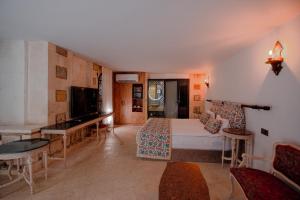 a bedroom with a bed and a desk and a television at Maridin Hotel in Mardin