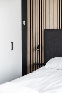 sypialnia z białym łóżkiem i czarnym zagłówkiem w obiekcie 2ndhomes Tampere "Kansi" Apartment - 15th Floor Apt with Jacuzzi and 60m2 Terrace w mieście Tampere