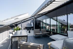 un balcone con tavolo e sedie su un edificio di "KANSI" - 15th Floor Penthouse with Jacuzzi & 60m2 Terrace, Hosted by 2ndhomes a Tampere