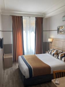 a bedroom with a large bed and a window at Hotel Phenix Paris in Paris