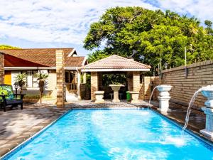 a swimming pool with a water fountain in front of a house at Hornbill Family Suites in St Lucia