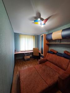un soggiorno con divano e ventilatore a soffitto di Трёхкомнатные апартаменты a Kryvyj Rih