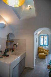 a kitchen with a sink and a living room at Arck Suites in Foinikiá