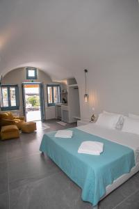 ein großes Schlafzimmer mit einem großen Bett mit blauer Bettwäsche in der Unterkunft Arck Suites in Foinikiá