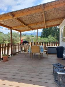 una terraza de madera con pérgola con mesas y sillas en Stacaravan el toro Alhaurin en Alhaurín el Grande