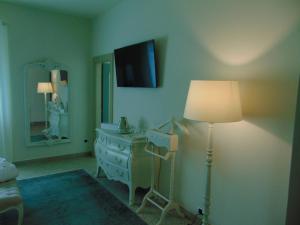 a room with a lamp and a dresser and a mirror at Galleria Imperiale Suites in Sarnico
