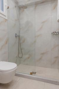 e bagno con servizi igienici e doccia in vetro. di Naxos Alegria Luxury Apartment a Naxos Chora