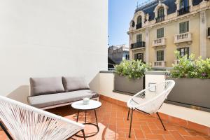 balcone con divano e sedie sul tetto di Murmuri Residence Mercader a Barcellona