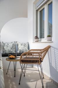 a rattan chair and a table in front of a couch at Naxos Alegria Luxury Apartment in Naxos Chora