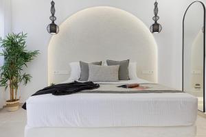 una camera con letto bianco e testiera bianca di Naxos Alegria Luxury Apartment a Naxos Chora