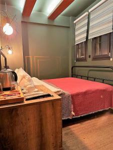 Sunset Boutique Hotel Marmaris في مرماريس: غرفة نوم بسرير وطاولة مع بطانية حمراء
