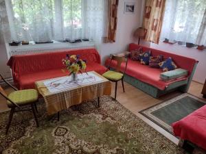 a living room with a red couch and a table at Dom pod Tatrami. in Veľký Slavkov