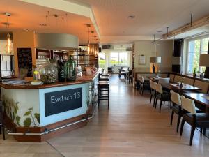 a restaurant with a bar and tables and chairs at Ewitsch 13 - Hotel Garni in Berghausen