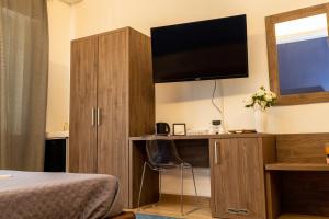 a bedroom with a desk with a television and a bed at Exclusive in Palermo