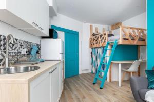 a kitchen with a bunk bed and a kitchen with a ladder at Le Rêve Bleu in Brest +2 photos