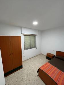 una camera con letto, cassettiera e finestra di Alojamiento Marmolejo a Marmolejo