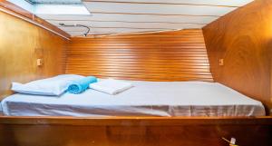 a bed in a wooden room with two towels on it at Cyclades sailing Experience in Finikas