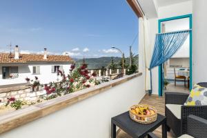 - un balcon avec une table et une corbeille de fruits dans l'établissement Appartamento A_Mati a Baunei, à Baunei