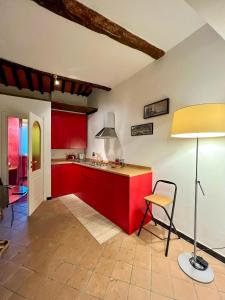 uma cozinha com armários vermelhos, uma mesa e um candeeiro em Casa Ida em Lerici