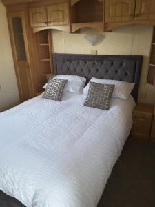 a large white bed with two pillows on it at Golden sands ingoldmells in Skegness
