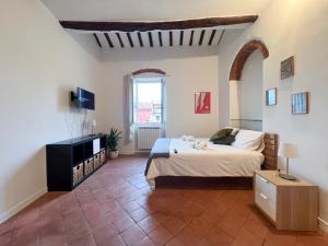 ein Schlafzimmer mit einem Bett und einem TV in einem Zimmer in der Unterkunft Casa Ida in Lerici