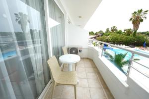 a balcony with a table and chairs and a pool at Side Beach Club in Side