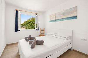 a white bedroom with a bed with towels on it at Casa Kintore A beautiful family friendly villa situated in the heart of S’Algar in S'Algar +18 photos