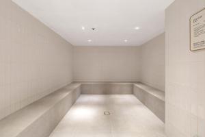 an empty waiting room with white walls and a ceiling at ULTIQA Signature at Broadbeach in Gold Coast