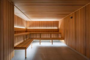 a sauna with wooden walls and a wooden bench at ULTIQA Signature at Broadbeach in Gold Coast