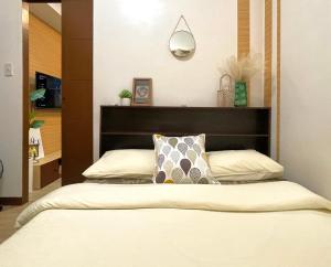 - une chambre avec un lit et une tête de lit dans l'établissement Althea's Cozy Apartment, à Manille
