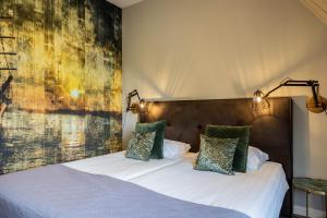 ein Schlafzimmer mit einem Bett mit einem großen Gemälde an der Wand in der Unterkunft Hotel De Walvisvaarder in Lies