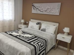 a bedroom with a bed with two people laying on it at Ático frente al mar con parking para 5 personas in Calafell