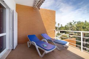 two blue chairs and a table on a balcony at Yara Beach Apartments T1 in Albufeira