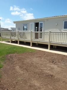 a house with a porch with a white railing at Golden sands ingoldmells in Skegness