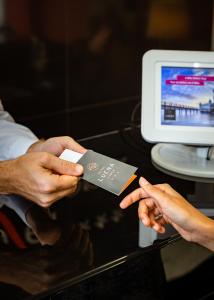 dos personas con una tarjeta de crédito frente a un ordenador en Hotel Luena, en Lisboa