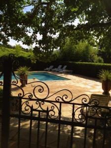 una recinzione con panchina accanto alla piscina di Les Gites du Merle a Cogolin