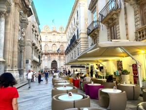 a group of tables and chairs in a city street at Marilù Home in Trapani