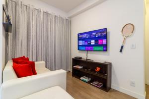 a living room with a white couch and a flat screen tv at Apto próximo ao Estádio Morumbi in Sao Paulo