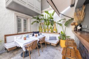 a patio with two tables and chairs and plants at Blue Alle Alaçatı in Alaçatı