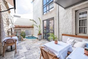 a patio with tables and chairs and a pool at Blue Alle Alaçatı in Alaçatı