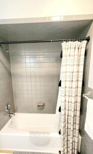 a white bath tub with a shower curtain in a bathroom at Lake house to relax and rest in Inverness