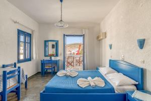 a bedroom with a blue bed with bows on it at Alpha Studios in Naousa