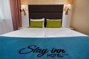 a bed with a stay in hotel sign on it at Stay inn Hotel Gdańsk in Gdańsk