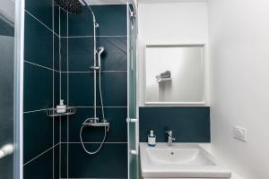 La salle de bains est pourvue d'un lavabo et d'une douche. dans l'établissement La Cabane Urbaine, à Brest