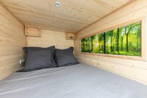 Ce lit se trouve dans une cabane en bois dotée d'une fenêtre. dans l'établissement La Cabane Urbaine, à Brest