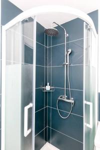 La salle de bains est pourvue d'une douche et d'un mur bleu. dans l'établissement La Cabane Urbaine, à Brest