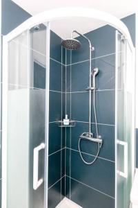 a shower in a bathroom with a blue wall at La Cabane Urbaine in Brest